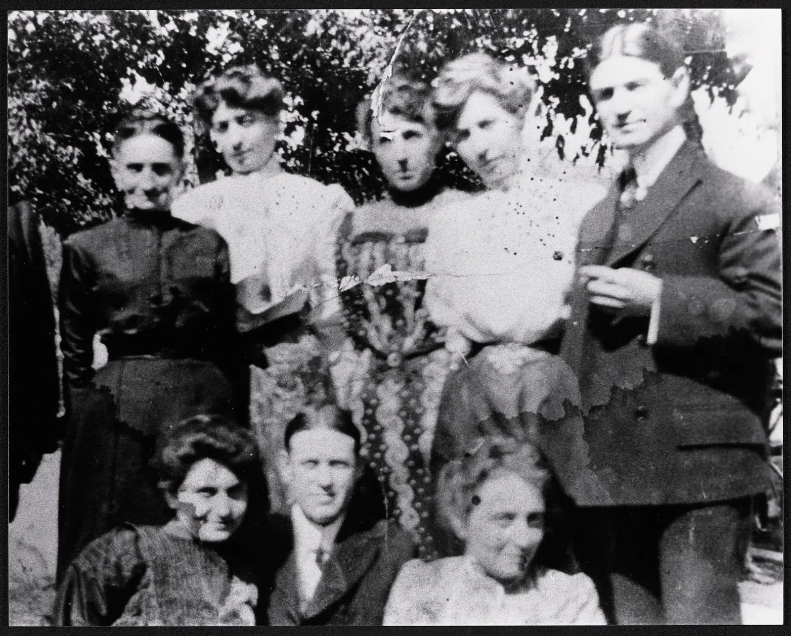 Original: A family group of eight photographed outdoors in 1904